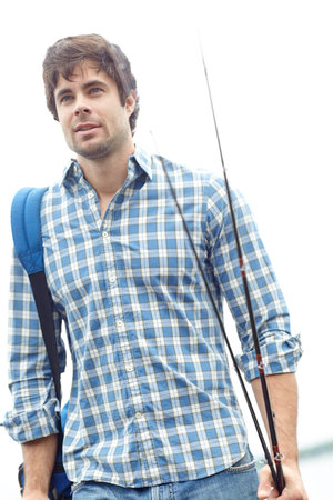 Man, fisher and walking with rod at lake with backpack for sport, hobby or catch by ocean. Male...