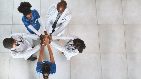 Doctor, team and meeting with hands together above at hospital for collaboration, health campaign or unity. Top view, people or healthcare group piling with circle for medical development on spaceの写真素材