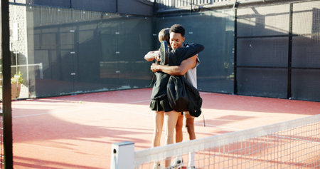 Happy people, hug and tennis with love for game, match or friendly sportsmanship on court or turf. Man, woman or friends with embrace for fitness, workout or outdoor bonding together on sports groundの写真素材