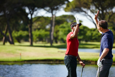 Happy man, high five and celebration with golf course for winning, point or score in outdoor nature. Male person, friends or people success with smile for teamwork, victory or match on grass fieldの写真素材