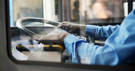 Bus driver, hands and man with public transportation, commute and traffic. Person, closeup and employee for city, steering wheel and morning route for pickup, urban journey or service in New Yorkの写真素材