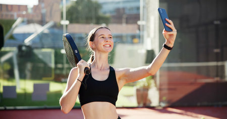 Sports, happy and selfie of woman on tennis court for training, match and playing game outdoors. Fitness club, racket and person smile for exercise, workout and practice with photo for social mediaの写真素材