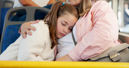 Mother, bus and sleeping with girl, travel and commute with passengers, resting and calm. Family, parent and mama with daughter, embrace and tired in city, fatigue and exhausted with break and relaxの写真素材