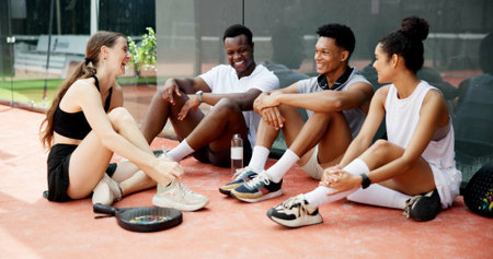 Tennis, sports or team break on court with resting, funny conversation or match practice. Padel, happy friends or laughing at fitness training for tournament support or bonding together after workoutの写真素材
