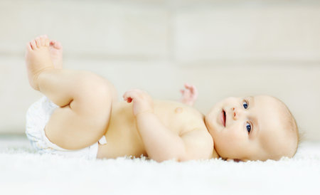 Baby, home and lying on floor, portrait and play for development, curious and happy in lounge....