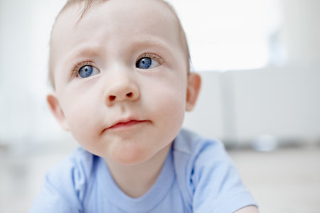 Baby, curious and thinking for play at house of sensory development, discovery learning and growth. Closeup, kid and crawl for motor skills, coordination and educational mobility of wellness activityの写真素材