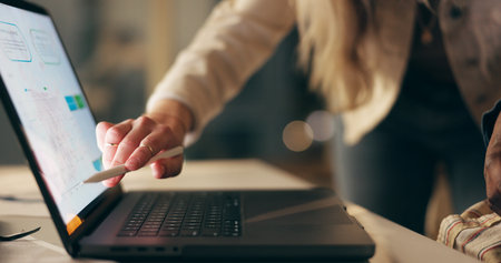 Laptop, screen and business people together at night for advice, online feedback and planning for web design. Teamwork, partnership and consulting for development, digital project and dark officeの写真素材