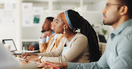 Business people, team and writing notes in training, workshop or watch video for development in...