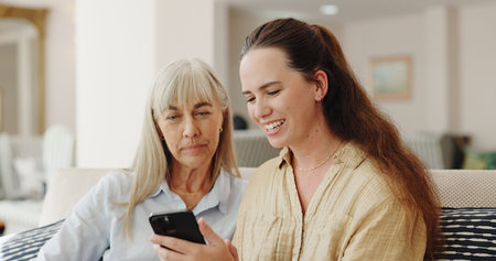 Happy, senior mom and daughter with smartphone on sofa for teaching, learning and support with care....