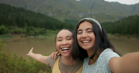 Happy woman, friends and selfie in nature for social media, picture or vlog with natural scenery. Female person or people smile in photograph, capture or moment together on outdoor adventure in woodsの写真素材