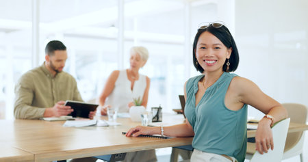Portrait, happy or woman in a meeting planning a branding, advertising or marketing strategy with business people. Partnership, face or Japanese worker smiles with pride after a successful projectの写真素材
