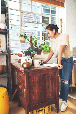 Asian woman, pottery or business owner with laptop for research, creative design or startup at...