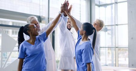High five, group of nurses and doctors in healthcare with success, support and celebration for medical win at hospital. Men, women and health, diversity and teamwork, hands together for achievementの写真素材