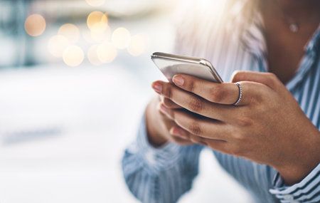 Hands, phone and contact with business woman in office for client feedback, communication and app. Online news, networking and virtual advisor with person and mobile for closeup, space and typingの写真素材