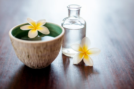 Flower, spa and holistic aromatherapy on table with water, peace and natural fragrance in bowl. Health, hospitality service and counter with essential oil for self care at luxury wellness salonの写真素材