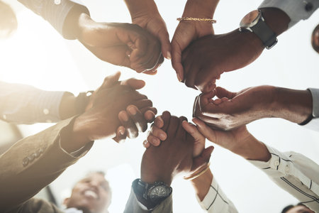 Business people, company and holding hands in circle at office for trust, support and solidarity. Low angle, partnership and employees with gesture of motivation for collaboration, agreement and careの写真素材