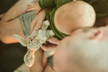Relax, toy and father with baby at home from top view for cute, cuddle and bonding. Child development, learning and youth with kid and man with stuffed rabbity for happiness, newborn and careの写真素材