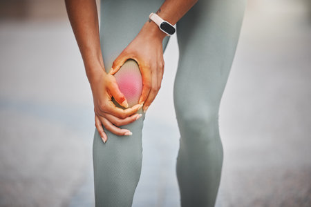 Knee pain, sports and woman with red glow in city for muscle sprain with running exercise. Fitness, injury and female athlete with nerve compression in leg for cardio workout or race training in townの写真素材