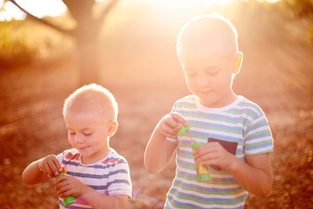 Sunshine, blowing bubbles and children in nature for fun, childhood and bonding together outdoors....