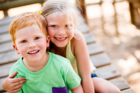 Smile, portrait and children hugging in park for bonding, connection or adventure together. Love, siblings and kids embracing outdoor on playground for development, growth and exploring in nature.の写真素材