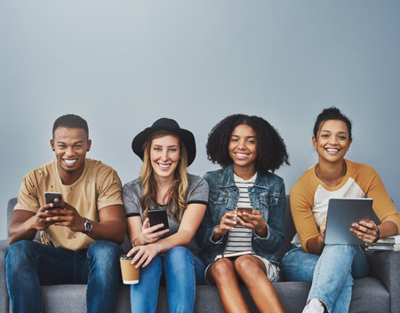 Portrait, smartphone and group with tech, studio and smile for communication on break, relax or online. Happy, Gen z and people with social media, digital and friends with app for texting or internetの写真素材