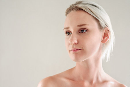 Studio, woman and thinking with ideas for skincare, beauty treatment and smooth glow with confidence. Mockup space, female person and benefits with cosmetics for wellness, salon and white backgroundの写真素材