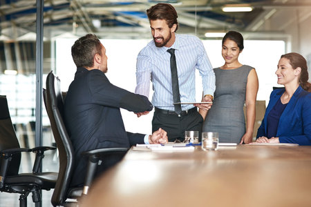 Shaking hands, meeting and business people in office with client for investment deal, offer or agreement. Discussion, negotiation and finance analysts with corporate investor for onboarding handshakeの写真素材
