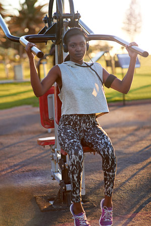 African, woman and exercise with machine outdoor for arms performance, sports workout and listening...