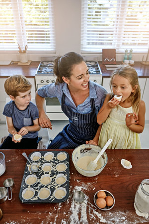 Happy kids, baking or eating with mom, cupcake or help for bonding, dessert or joke in home. Smile,...