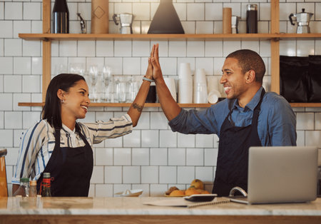 Waiter, people and happy in cafe with high five for startup success, funding loan approval or achievement. Restaurant, partnership or excited owners with celebration for sale target or small businessの写真素材