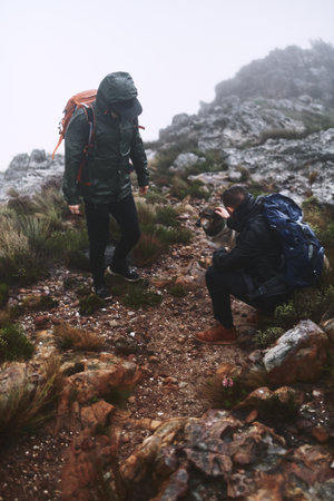 People, hiking and outdoor to pet dog, extreme terrain and nature for winter adventure. Travel, friends and trekking journey on remote vacation, explore wilderness and together to stroke animalの写真素材