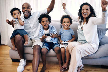 Celebration, parents and kids gaming in home for bonding in living room together. Happy, entertainment and boy children playing online esports with mother and father cheering for win on sofa in houseの写真素材