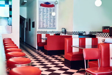 Small business, empty and retro diner with chairs, decorations and stool with restaurant. Indoors, cafe and interior design with hospitality, red stools and vintage accessories with equipmentの写真素材