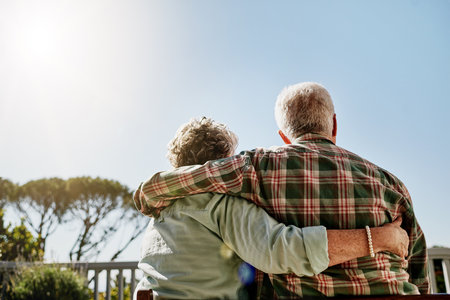 Hugging, back and senior couple outdoor at holiday house together for retirement celebration. Love, bonding or elderly man and woman embrace by balcony on anniversary vacation for marriage connectionの写真素材