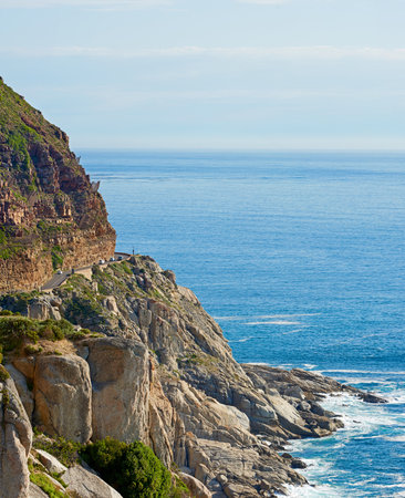 Mountain, road and sea with rocks, water and destination for travel getaway by ocean in nature. Island tourism, highway and beach with scenic paradise, holiday and vacation adventure in Indonesiaの写真素材