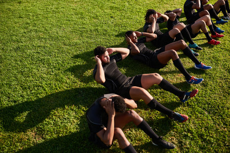 Crunches, people and outdoor for rugby warm up, community workout and group for sports. Men, performance and professional athletes together for training, practice and fitness to prepare for gamesの写真素材