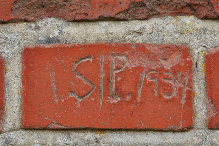 Scratch, writing and word on brick wall of building in city for background, pattern and exterior design. Construction, architecture and closeup of graffiti or texture on stone, concrete and cementの写真素材
