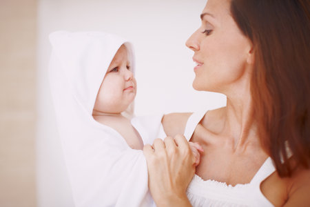 Mother, child and towel for care in home, bonding and hygiene routine for baby grooming. Family, mommy and toddler daughter for happiness in apartment, love and support for security in relationshipの写真素材