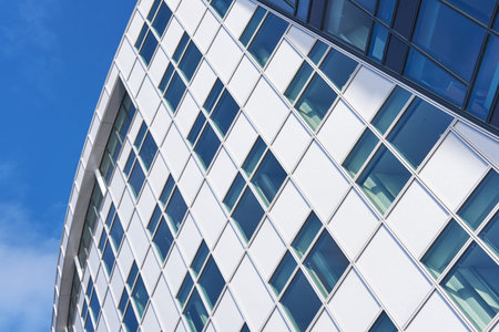 Building, architecture and glass windows with blue sky below of industrial construction. Low angle,...