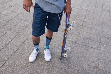 Man, skateboarder and legs in urban city, rider and guy for skating challenge on vacation. Fitness, outdoor hobby and board for practice in downtown, recreation culture and person ready for stuntの写真素材
