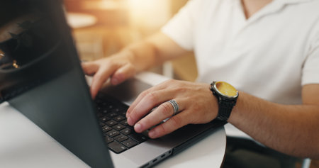 Remote work, hands and typing on laptop in cafe for email communication, online report and freelancing. Entrepreneur, man and technology in coffee shop for business, startup proposal and web researchの写真素材