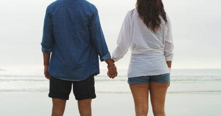 Back, holding hands and love with couple on beach for date, summer vacation and support. Relax,...