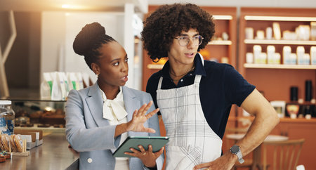 Business people, waiter or tablet in coffee shop, internet or service with connection. Employees, store manager or server in restaurant, technology or conversation with app for pricing or menu choiceの写真素材