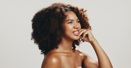 Glow, skincare and beauty with woman in studio for spa treatment, self care and cosmetics. Aesthetic space, collagen and dermatology with African person on white background for shine, smile and salonの写真素材