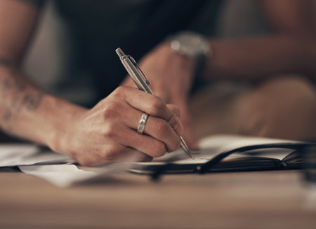 Finance, hands of man and writing notes with invoice, home budget and income tax report. Financial plan, asset management and person with notebook, paperwork and insurance application billsの写真素材