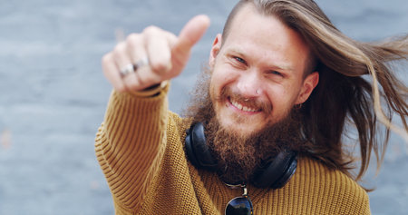 Thumbs up, happy and portrait of man in city with hand gesture for success, support and approval. Smile, urban town and person with emoji, sign and symbol for agreement, good news and okay outdoorsの写真素材