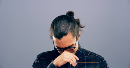 Crying, sad and man in studio with emotions, heartbreak and grief on gray background space. Tears, mourning and isolated lonely person with depression, upset and unhappy for breakup, bad news or painの写真素材
