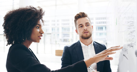 Woman, man and discussion by board, finance and review for profit, revenue or increase with insight at office. Business people, team and accounting for notes, feedback and talk with stats at agencyの写真素材