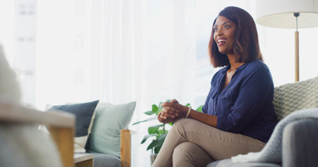 Therapy, talking and counseling with black woman on sofa for meeting, advice and mental health. Psychologist, support and consulting with person in therapist office for discussion and helpingの写真素材