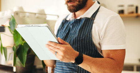 Man, hands and waiter with tablet in coffee shop for planning menu, online order and schedule in startup. Technology, small business and barista in cafe for stock, check inventory and communicationの写真素材